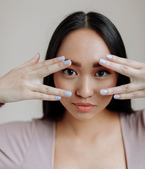 A serene woman with closed eyes, focusing inward, bathed in a calm, gentle light.